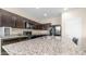 Kitchen with granite countertops, modern stainless steel appliances, and dark cabinets at 44232 W Palo Cedro Rd, Maricopa, AZ 85138