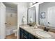 Bathroom featuring dual sinks, granite countertops, dark blue cabinets, and a shower/tub combo at 4684 W Tyson St, Chandler, AZ 85226