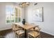 Bright dining room featuring modern light fixture, hard wood floors and light colored furniture at 4684 W Tyson St, Chandler, AZ 85226