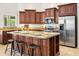 Close up of kitchen with stainless steel appliances, dark wood cabinetry, and a large island with seating at 4684 W Tyson St, Chandler, AZ 85226