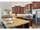Close up of kitchen with stainless steel appliances, dark wood cabinetry, and a granite countertop island at 4684 W Tyson St, Chandler, AZ 85226