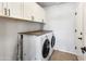 Laundry room with white cabinets, front loading washer and dryer on a countertop, and tile flooring at 4684 W Tyson St, Chandler, AZ 85226