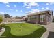 Lush backyard with a putting green, desert landscaping, and partial view of neighborhood pool at 5332 E Thunder Hawk Rd, Cave Creek, AZ 85331
