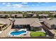 Aerial view of a backyard with a pool, covered patio, and putting green in desert landscape at 5332 E Thunder Hawk Rd, Cave Creek, AZ 85331