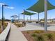 Park area featuring playground, sun shades, walking path, picnic tables, and desert landscaping at 5464 S 246Th Ln, Buckeye, AZ 85326