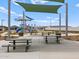 Picnic tables at park featuring playground, sun shades, walking path, and desert landscaping at 5464 S 246Th Ln, Buckeye, AZ 85326