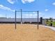 View of a pair of community swings in a mulch-covered playground area on a sunny day at 5464 S 246Th Ln, Buckeye, AZ 85326