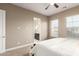 Carpeted bedroom with large windows, neutral walls, and a glimpse into the ensuite bathroom at 6648 S Lyon Dr, Gilbert, AZ 85298