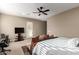 Bedroom featuring carpeted floors, ceiling fan, walk-out door, couch, and television at 6648 S Lyon Dr, Gilbert, AZ 85298