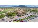 Aerial view of the community clubhouse, with parking lot and golf course beyond, on a sunny day at 6648 S Lyon Dr, Gilbert, AZ 85298