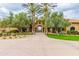 Elegant clubhouse entrance with palm trees and manicured landscaping, inviting residents and guests to a vibrant community space at 6648 S Lyon Dr, Gilbert, AZ 85298