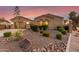 Beautifully landscaped front yard with desert plants, river rock, and mature trees enhancing the curb appeal of this desert home at 6648 S Lyon Dr, Gilbert, AZ 85298