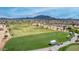 Aerial view of the beautifully maintained golf course, set against a backdrop of mountain views at 6648 S Lyon Dr, Gilbert, AZ 85298