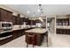 Spacious kitchen with granite island, stainless appliances, tile backsplash, and stylish bar stools at 6648 S Lyon Dr, Gilbert, AZ 85298