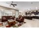 Open-concept living space with comfortable leather furniture, an entertainment center, and a view of the kitchen island at 6648 S Lyon Dr, Gilbert, AZ 85298