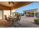 Covered patio featuring an outdoor dining area and a view of the backyard pool and pergola at 6648 S Lyon Dr, Gilbert, AZ 85298