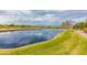 Picturesque pond surrounded by lush green grass and a golf course, creating a serene and scenic environment at 6648 S Lyon Dr, Gilbert, AZ 85298