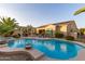 Backyard pool and spa with a covered patio, outdoor dining and lounging, palm trees, and lovely desert landscaping at 6648 S Lyon Dr, Gilbert, AZ 85298