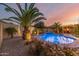 Inviting backyard pool with water feature, lush landscaping, and cozy pergola seating area at 6648 S Lyon Dr, Gilbert, AZ 85298