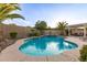 Inviting pool area with lush palms, a waterfall feature, and a covered pergola for lounging poolside at 6648 S Lyon Dr, Gilbert, AZ 85298