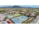 Aerial view of the community recreation area with pools, courts, and a clubhouse with mountain views at 6648 S Lyon Dr, Gilbert, AZ 85298