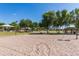 A sand volleyball court with a net, poles, and yellow boundary lines is a great place to get some exercise at 6648 S Lyon Dr, Gilbert, AZ 85298