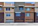 Contemporary townhome exterior showcasing multiple units with unique color schemes, attached garages, and modern design at 6745 N 93Rd Ave # 1158, Glendale, AZ 85305