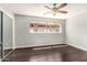 Bedroom featuring wood-look flooring, neutral walls, a window, a ceiling fan, and sliding mirrored closet doors at 725 S Power Rd # 101, Mesa, AZ 85206