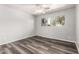 Bedroom featuring wood-look flooring, neutral walls, a window with a view of trees, and a ceiling fan at 725 S Power Rd # 101, Mesa, AZ 85206