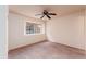 Neutral bedroom featuring a ceiling fan, carpeted floors, and a window offering natural light at 860 N Mcqueen Rd # 1151, Chandler, AZ 85225