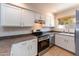 Well-lit kitchen boasting white cabinets, stainless steel appliances, and tile floors at 860 N Mcqueen Rd # 1151, Chandler, AZ 85225