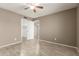 Cozy bedroom featuring wood-look tile flooring, an open closet, and a ceiling fan at 9106 N 68Th Ln, Peoria, AZ 85345