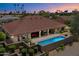 Aerial view of pool and landscaped backyard at dusk. Covered patio with living and dining at 10152 E Aster Dr, Scottsdale, AZ 85260