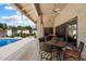 Covered patio with a table and chairs overlooking the sparkling pool and lush landscaping at 10152 E Aster Dr, Scottsdale, AZ 85260