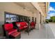 Covered patio with ceiling fans, plush red seating, and views of the pool and backyard at 10152 E Aster Dr, Scottsdale, AZ 85260