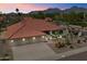 Charming home with a three-car garage, desert landscaping, and a red tile roof, set against a mountain backdrop at 10152 E Aster Dr, Scottsdale, AZ 85260