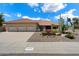 Front of home with three-car garage, desert landscaping and rock groundcover with bright flower accents at 10152 E Aster Dr, Scottsdale, AZ 85260