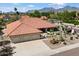 Home featuring a three-car garage, desert landscaping, and mountain views in the background at 10152 E Aster Dr, Scottsdale, AZ 85260