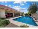 The sparkling pool is surrounded by a covered patio and lush landscaping at 10152 E Aster Dr, Scottsdale, AZ 85260