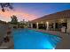 Backyard swimming pool at dusk featuring patio area with shade and outdoor living at 10152 E Aster Dr, Scottsdale, AZ 85260