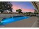 Swimming pool with tiled water feature wall in backyard at dusk at 10152 E Aster Dr, Scottsdale, AZ 85260