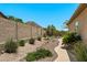 Well-maintained backyard features desert landscaping, a putting green, and a serene ambiance at 1078 W Desert Aster Rd, San Tan Valley, AZ 85143