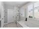 Luxurious bathroom featuring a soaking tub, glass shower, and plantation shutters, creating a spa-like retreat at 1078 W Desert Aster Rd, San Tan Valley, AZ 85143