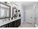 Elegant bathroom featuring dual sinks, decorative mirrors, and a glass-enclosed shower, providing a spa-like experience at 1078 W Desert Aster Rd, San Tan Valley, AZ 85143