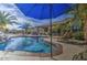 Backyard view of a swimming pool with palm trees, lounge chairs and patio at 1078 W Desert Aster Rd, San Tan Valley, AZ 85143