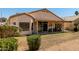Charming home with a covered patio surrounded by green grass and a low maintenance desert landscape at 11518 W Dana Ln, Avondale, AZ 85392