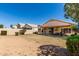 The backyard features a covered patio, green grass, desert landscaping and block fencing at 11518 W Dana Ln, Avondale, AZ 85392