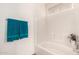 Clean, all-white bathroom with a bathtub, shower, and a decorative towel at 11518 W Dana Ln, Avondale, AZ 85392