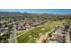 Aerial view of homes backing up to a golf course with mountain views in the distance at 12021 S Tomi Dr, Phoenix, AZ 85044