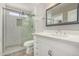 Bright bathroom featuring a glass enclosed shower, toilet and a white single sink vanity at 12021 S Tomi Dr, Phoenix, AZ 85044